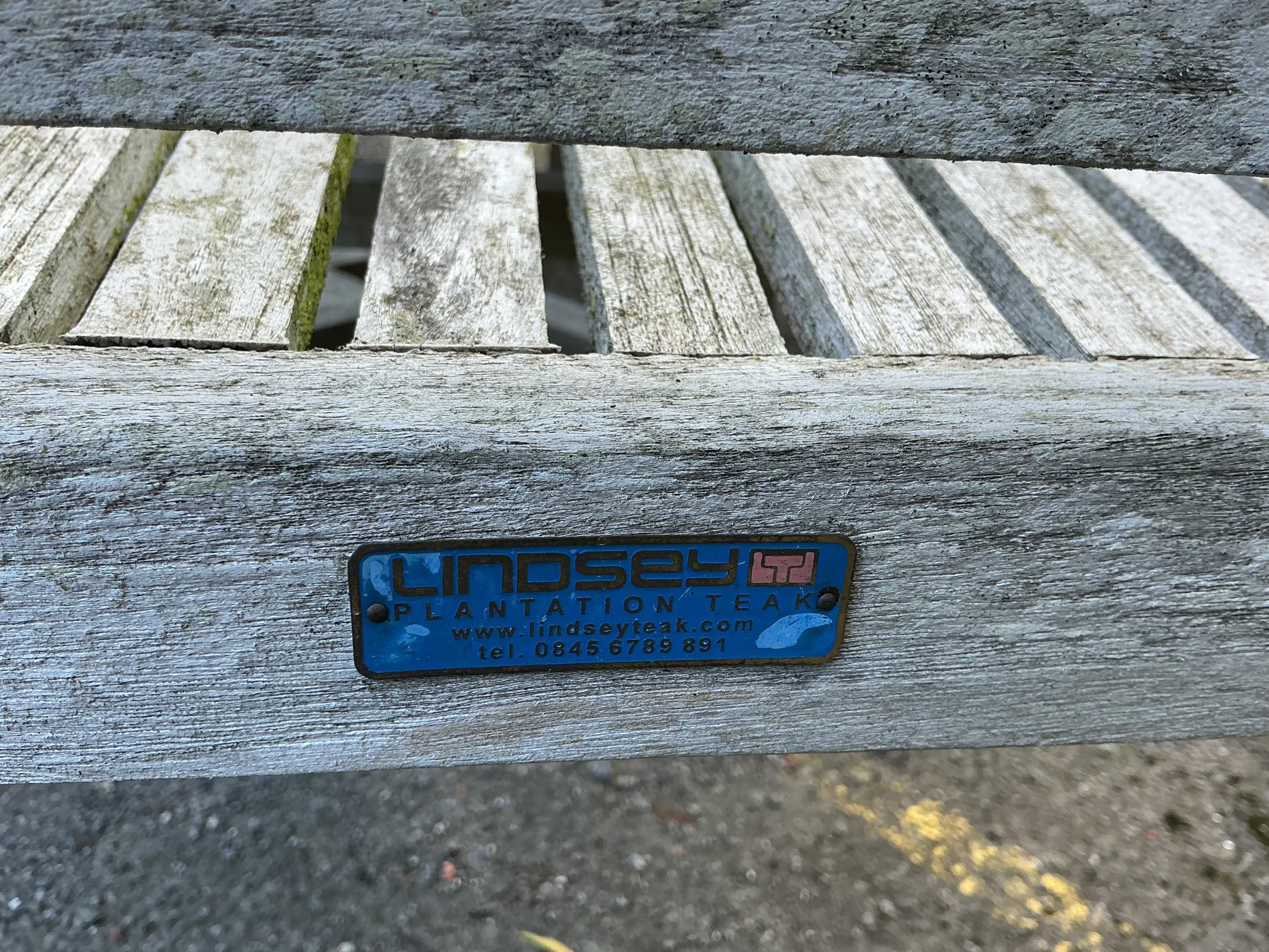 A Lindsey circular weathered teak garden table, diameter 130cm and four chairs